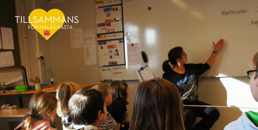 Lärare som sitter längst fram vid whiteboardtavla och undervisar en grupp barn på barnskolan i Malå.