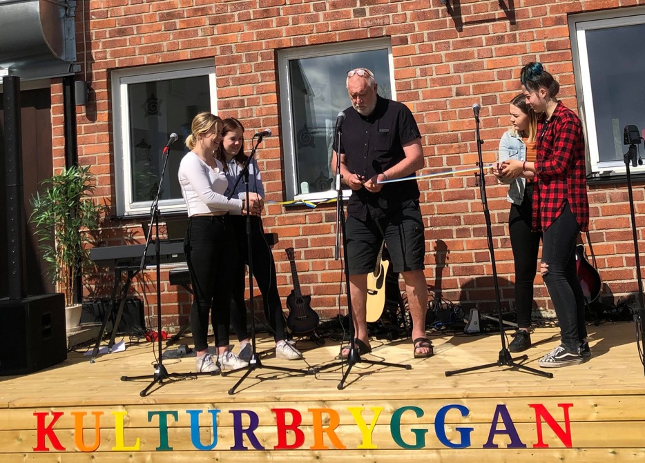 Utescen vid Kulturskolan invigs. Kommunstyrelsens ordförande Lennart Gustavsson klipper bandet tillsammans med några ungdomar.