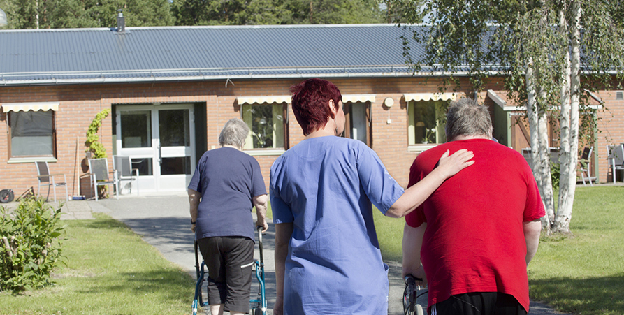Kvinnlig sköterska på sommarpromenad på vårdtagare på Furugården, äldreboende.