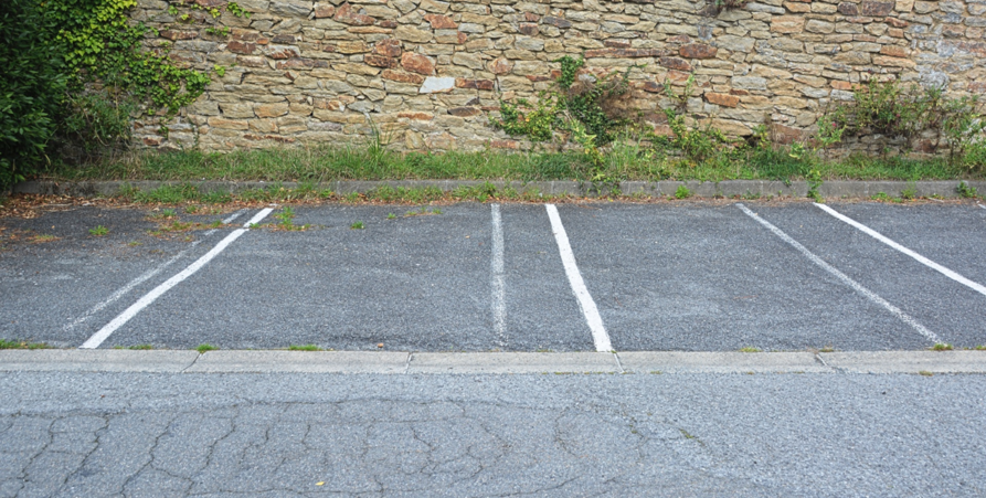 Uppritade linjer för parkering framför en mur.