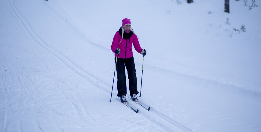 Kvinna som åker längdskidåkning.