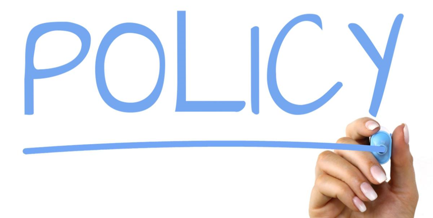 Hand som skriver Policy med blå penna